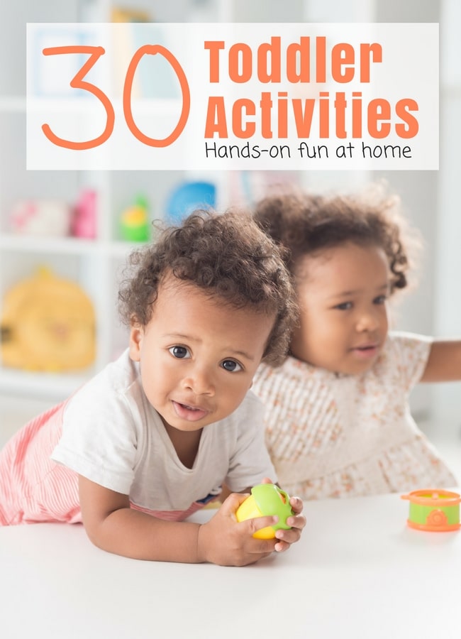 30+ Toddler Activities for Kids - The Educators' Spin On It 2 Toddlers Playing at White Table with Toddler Toys on Bookcase