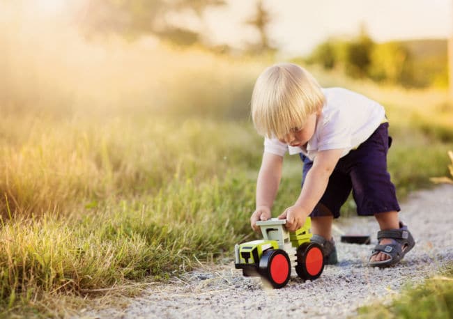 boy-playing-with-toy-car-outside - The Educators' Spin On It Boy playing with wooden toy car outside
