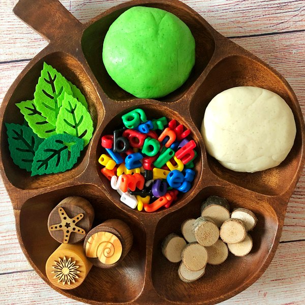 chicka-chicka-boom-boom-playdough-activity - The Educators' Spin On It green and white playdough on wooden tray with letter, wood and felt leave to make coconut tree