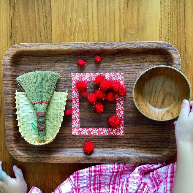 chinese-new-year-sweeping-activity-preschool - The Educators' Spin On It Young girl using small broom on wooden tray for Chinese New Year Activity