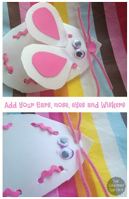 Adding pink ears, nose, eyes and pipecleaner whiskers to white mouse outline.