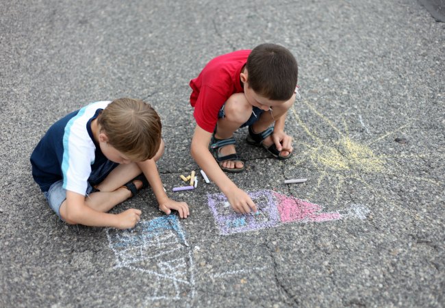 two young boys drawing with sidewalk chalk - family and kids - The Educators' Spin On It 2 boys playing with sidewalk chalk
