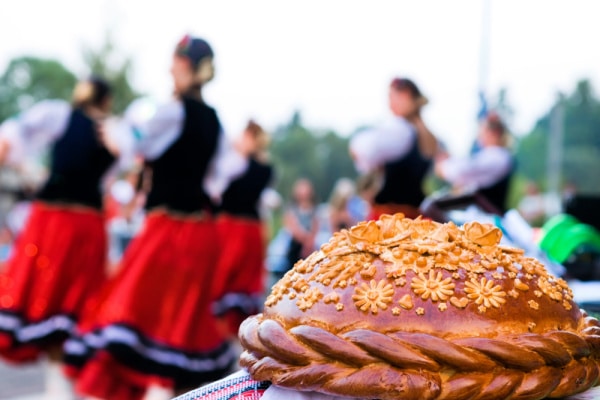 Festive loaf on a background of dancing people - The Educators' Spin On It Ukrainian festive Loaf of Bread with Ukrainian dancers in background
