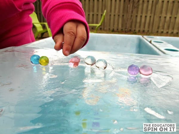 winter-science-water-beads-on-ice - The Educators' Spin On It child playing with water beads on ice sheet