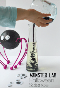 Halloween%2BScience%2BExperiment%2Bfor%2BKids%2Bby%2BKim%2BVij%2B.png - The Educators' Spin On It Glass Science beaker with child pouring mixture into with Googly Eyes and Black Spider watching